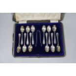 A cased set of eleven George V teaspoons and tongs by Cooper Brothers & Sons and one plated spoon.