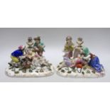 A pair of German porcelain figure groups of children wearing 18th century dress, each with floral