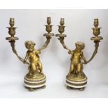 After Clodion (1738 –1814) Pair of two branch gilt bronze candlesticks in the form of Putti, each