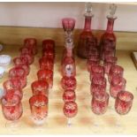 Cranberry glassware including a pair of cut glass decanters, together with a smaller pair and
