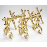 Two sets of brass fire dogs in Christopher Dresser style, the largest 18cm high