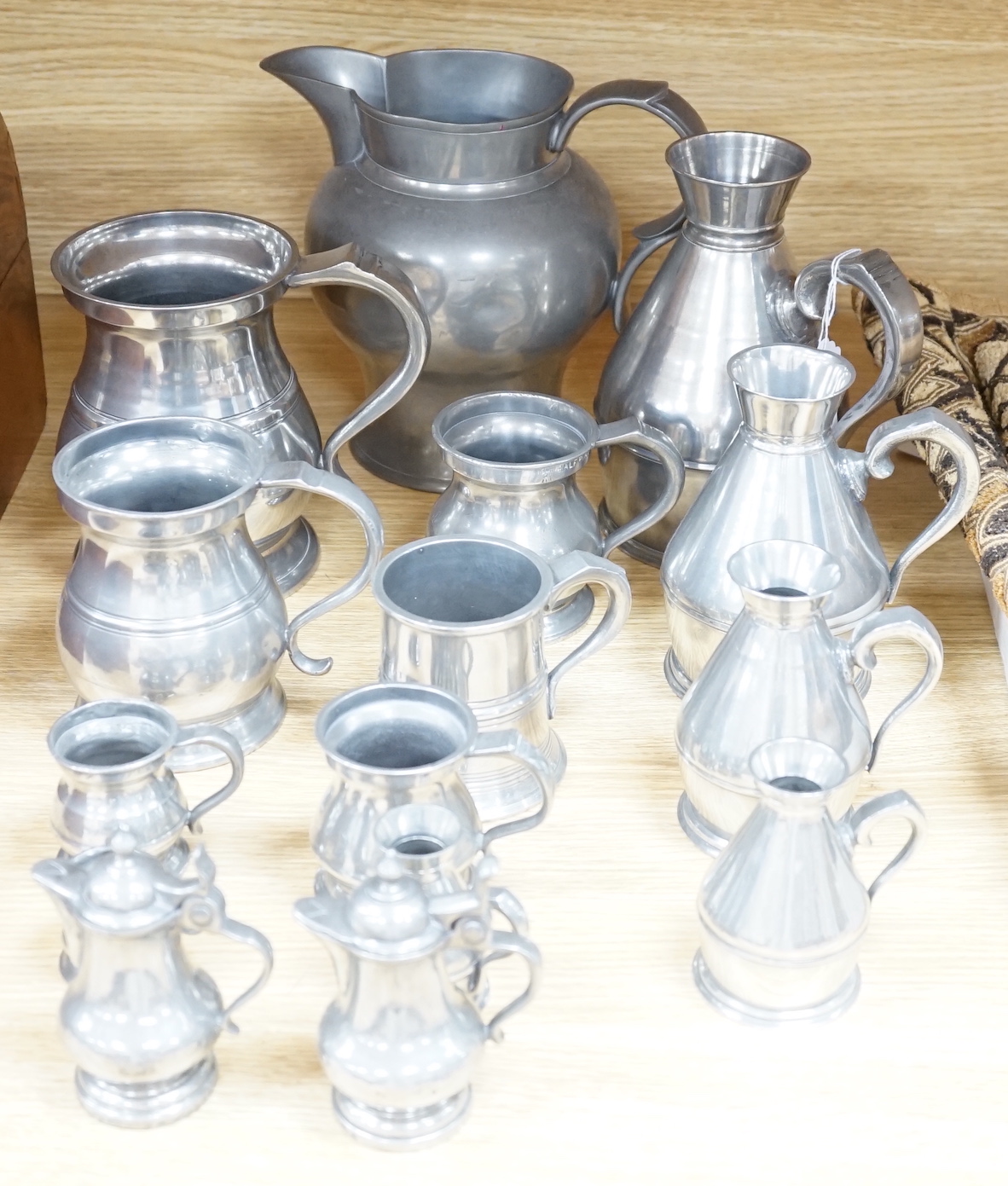 A collection of 19th/20th century pewter jugs, mugs and flagons (15), large jug 20cm high