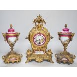 A 19th century porcelain mounted gilt spelter clock garniture, hand painted with landscapes, 30cm