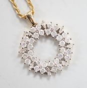 A modern 9ct gold, baguette and round cut diamond cluster set openwork pendant, diameter 17mm, gross