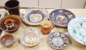 A group of Mediterranean slipware dishes, bowls and jugs, decorated in colours on a predominantly