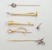 An Edwardian 15ct riding crop brooch(a.f.), 59mm, 2.8 grams, an 18ct hunting horn brooch (lacking