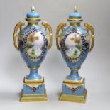 A pair of Japanese Noritake vases and covers, each hand painted with a river landscape, 29cm high