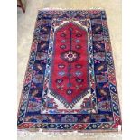 A Caucasian style red ground rug, 205 x 124cm