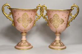 A pair of large Coalport salmon pink ground two handled loving cups, 28.5cm