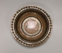 A Middle Eastern tinned copper bowl with embossed rim, 24cm in diameter