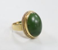An 18k and green cabochon stone set dress ring. size Q/R, gross weight 12.1 grams.
