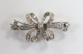 A white metal and diamond cluster set ribbon bow brooch, 45mm, gross weight 8.9 grams.