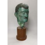 A verdigris metal head of a gentleman mounted on a wooden stand, 48cm high