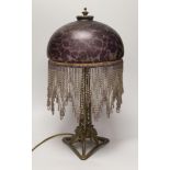 An Art Nouveau style metal lamp and glass shade with beaded fringe, 44cm high
