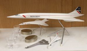 Concorde memorabilia comprising four British Airways glass tots, a pair of plated cased clothes