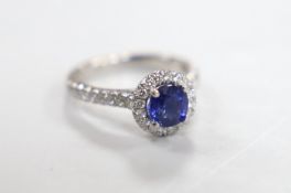 A modern platinum, sapphire and diamond cluster set ring, with diamond set shoulders, size G,