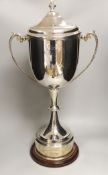 ‘The London Cup’, a large silver plated twin handled trophy and cover on circular wooden stand, 70cm