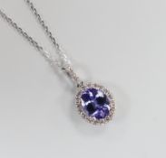 A modern 18k white metal, tanzanite and diamond set oval cluster pendant, 20mm, on a 750 fine link