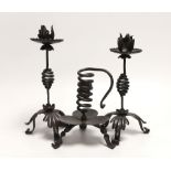 A pair of Arts & Crafts wrought iron candlesticks and a similar chamberstick, 1880s, made by Suffolk