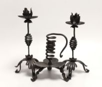 A pair of Arts & Crafts wrought iron candlesticks and a similar chamberstick, 1880s, made by Suffolk