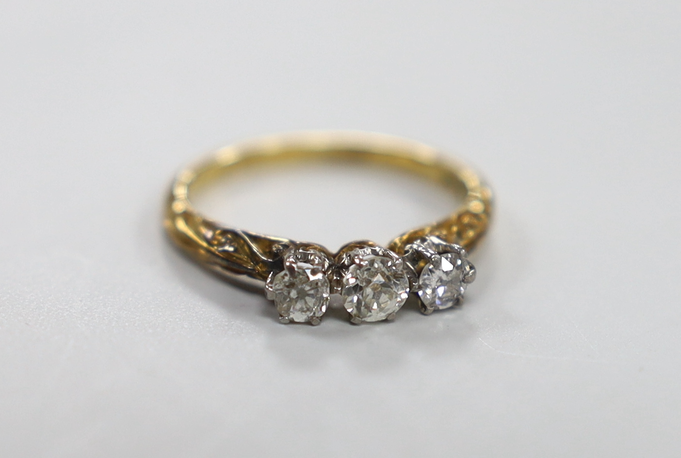 An 18ct and three stone diamond ring, size J, gross weight 2.2 grams.