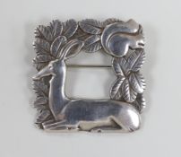 A Georg Jensen sterling recumbent deer and squirrel amongst foliage square brooch, design no. 318,