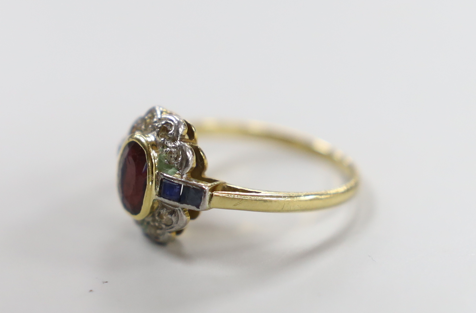 A 1920's/1930's yellow metal, ruby, sapphire and diamond set oval cluster ring, size O, gross weight - Image 2 of 3