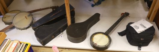 Four various banjo's, one cased together with a cased mandolin,