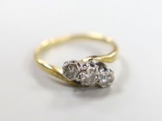 An 18ct, pt and illusion set three stone diamond crossover ring, size M, gross weight 2.7 grams.