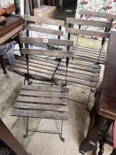 A set of four wrought iron slatted wood folding garden chairs