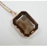 A yellow metal mounted smoky quartz pendant, 24mm, on a yellow metal fine link chain(a.f.), gross