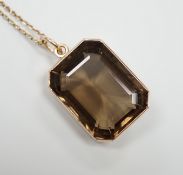 A yellow metal mounted smoky quartz pendant, 24mm, on a yellow metal fine link chain(a.f.), gross