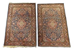 A pair of Kashan blue ground rugs, with central medallions within stylised floral field, multi-