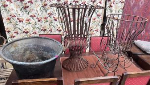 A pair of wrought iron circular garden frames, a magazine rack and a copper cauldron, largest height