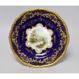 A Coalport gadroon-rimmed plate with elaborated blue and gilt border, painted with a central