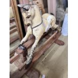 An early 20th century rocking horse on pine safety frame, length 152cm, height 98cm