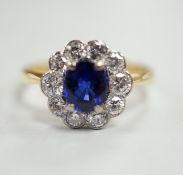 A modern 18ct gold, sapphire and diamond set circular cluster ring, size P/Q, gross weight 3.4