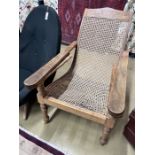 A caned hardwood plantation chair, cane seat damaged, width 66cm, depth 92cm, height 94cm