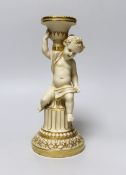 A rare Minton candlestick figure of a cherub seated on part of a column, holding a sonce on it's