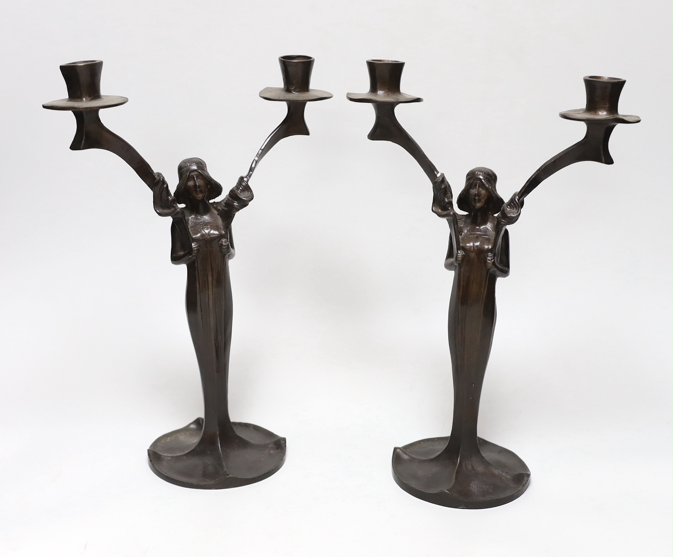 After Jules Moigniez (1835-1984) - a pair of bronze two branch candelabra, signed, dated 1902,