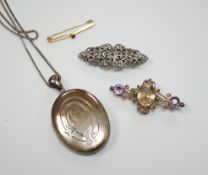 A white metal oval locket on chain, a white metal and marcasite clip brooch, a yellow metal and
