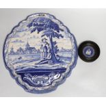 A framed Wedgwood jasperware circular plaque dated 1789 and a delft blue and white example, the