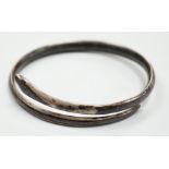A white metal and niello serpent bangle, decorated with scene of a camel train.
