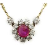 A modern 9ct gold, single stone oval cut ruby and eleven stone round cut diamond cluster set pendant