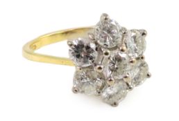 A modern 18ct gold and seven stone diamond set flower head cluster ring, size M/N, gross weight 3.