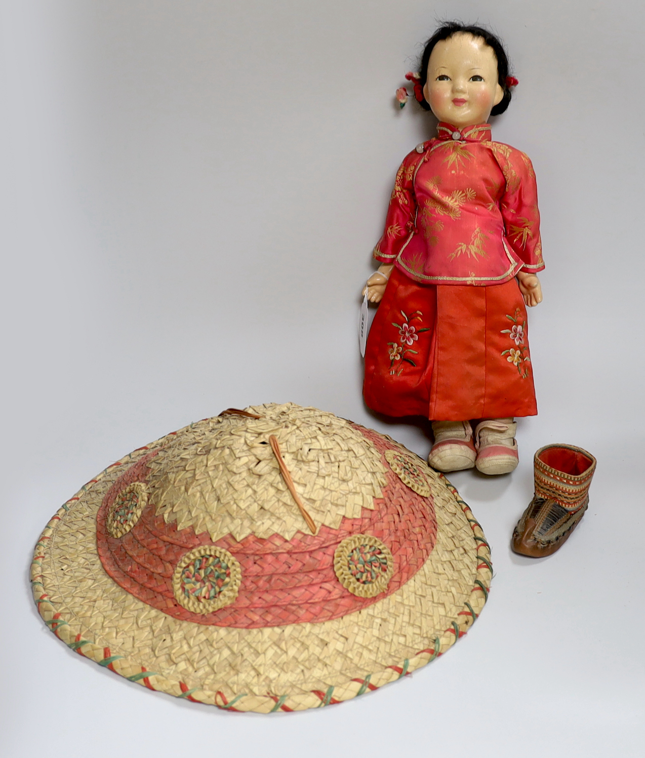 A composition Burmese doll, 40cm, related hat and a shoe