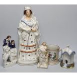 A tall Staffordshire pottery figure of Queen Victoria, a Staffordshire 'frog' mug and three