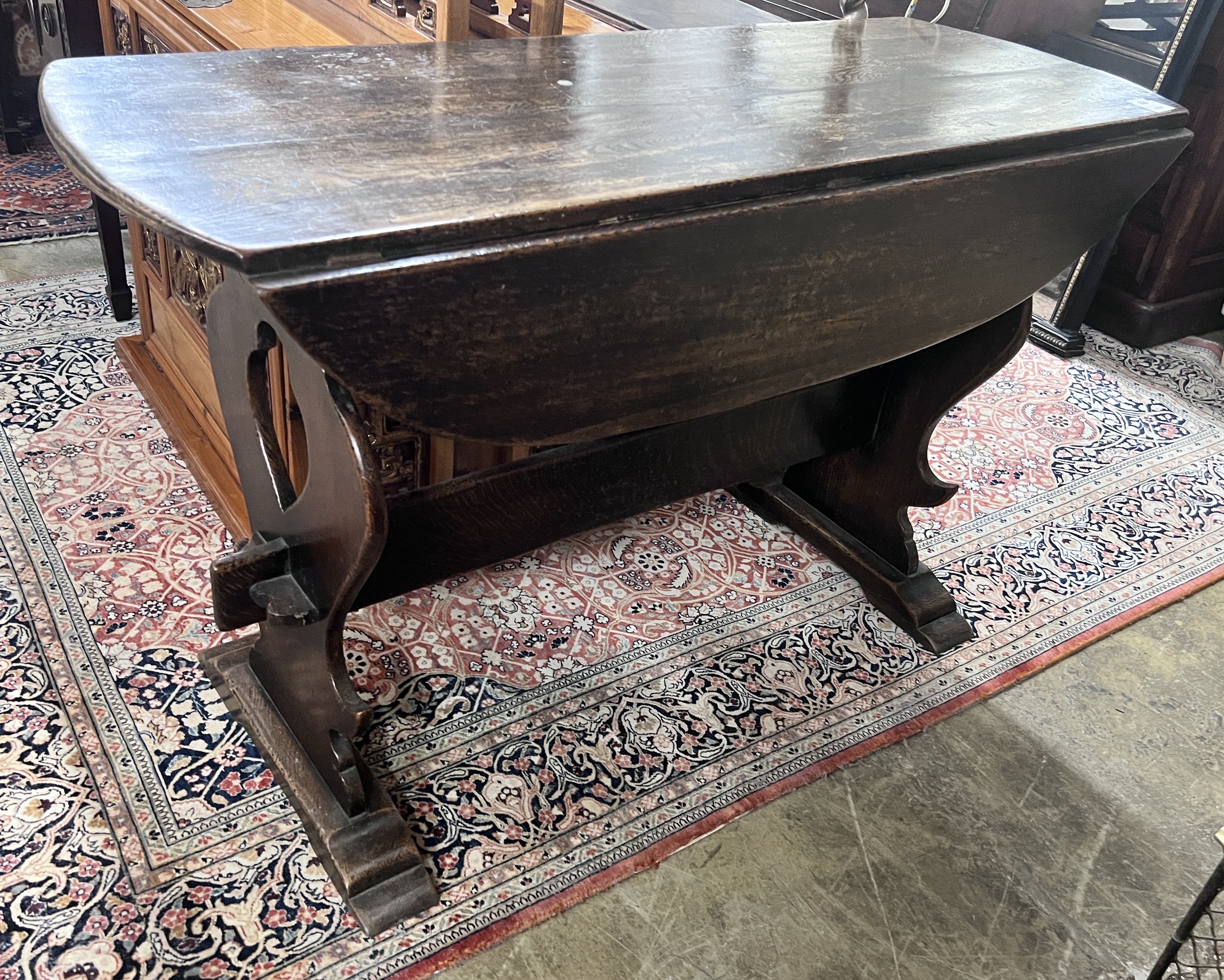 An 18th century style Spanish design oak drop leaf dining table, length 122cm, depth 45cm, height