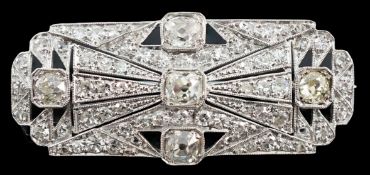 An Art Deco pierced platinum and millegrain set diamond cluster shaped rectangular brooch, set