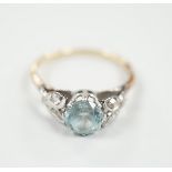 A yellow metal, plat and single stone blue zircon ring, with diamond chip set petal shoulders,